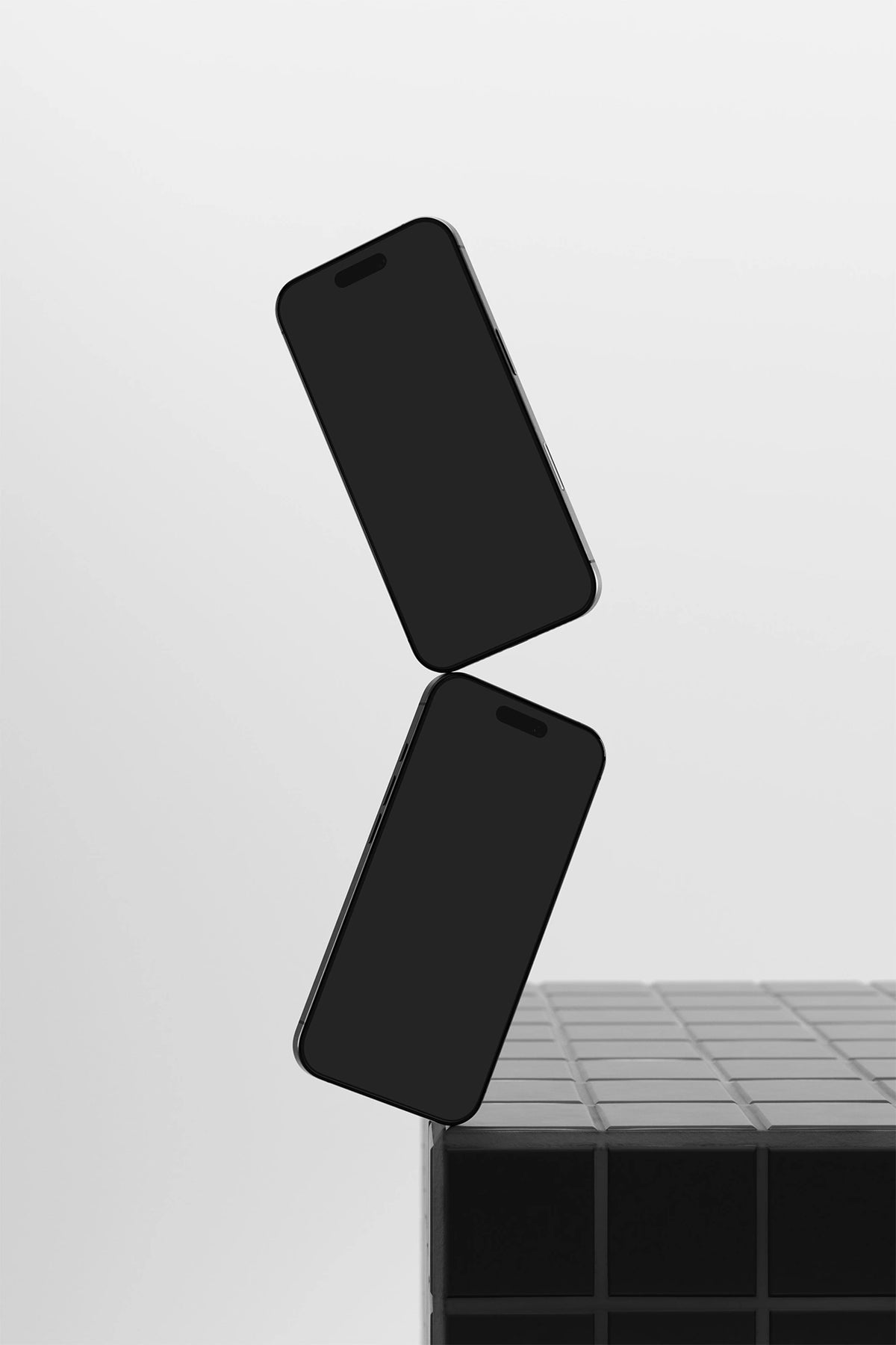 Two iphone mockups on a gray tile table with a black UI placeholder for web and desktop UI presentation, angled view