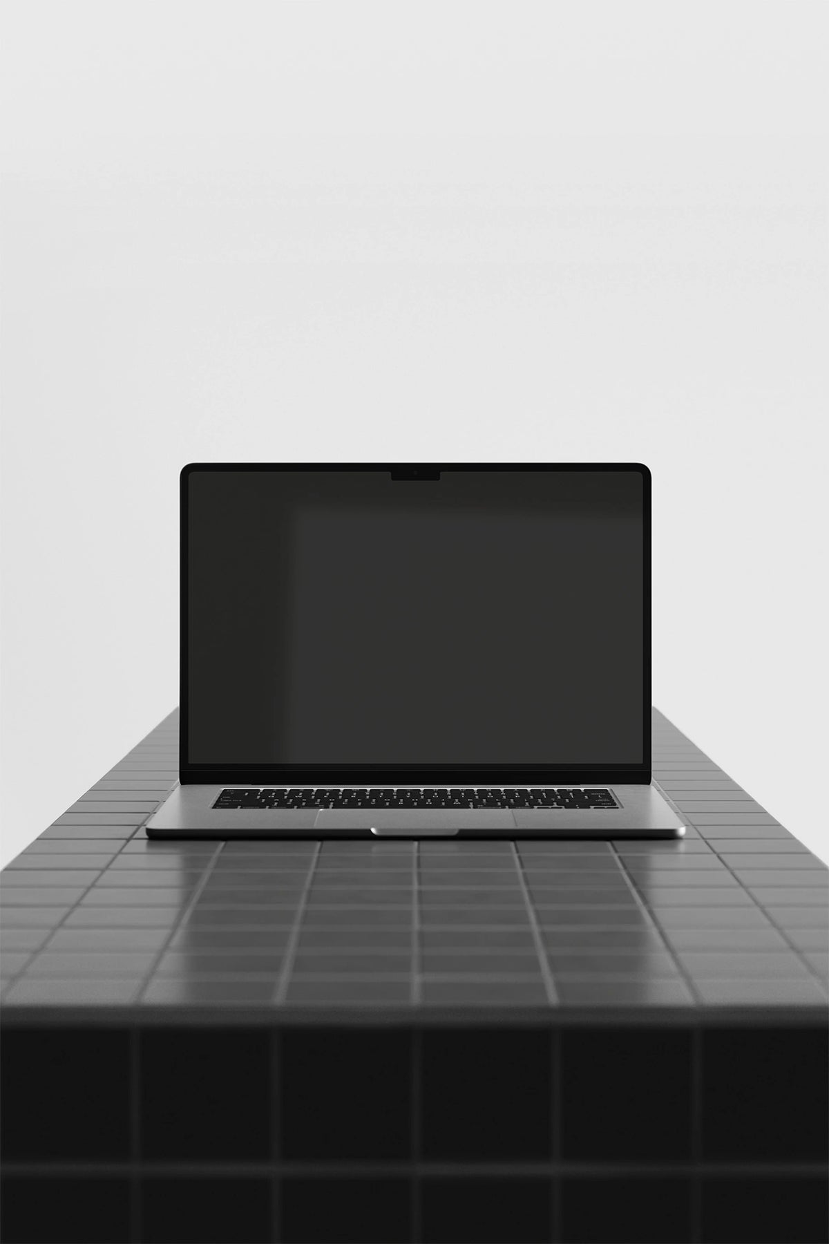 Laptop mockup on a gray tile table with a black UI placeholder for web and desktop UI presentation, front view